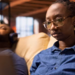 smiling-female-freelancer-browsing-web-her-laptop-modern-living-room_482257-118940
